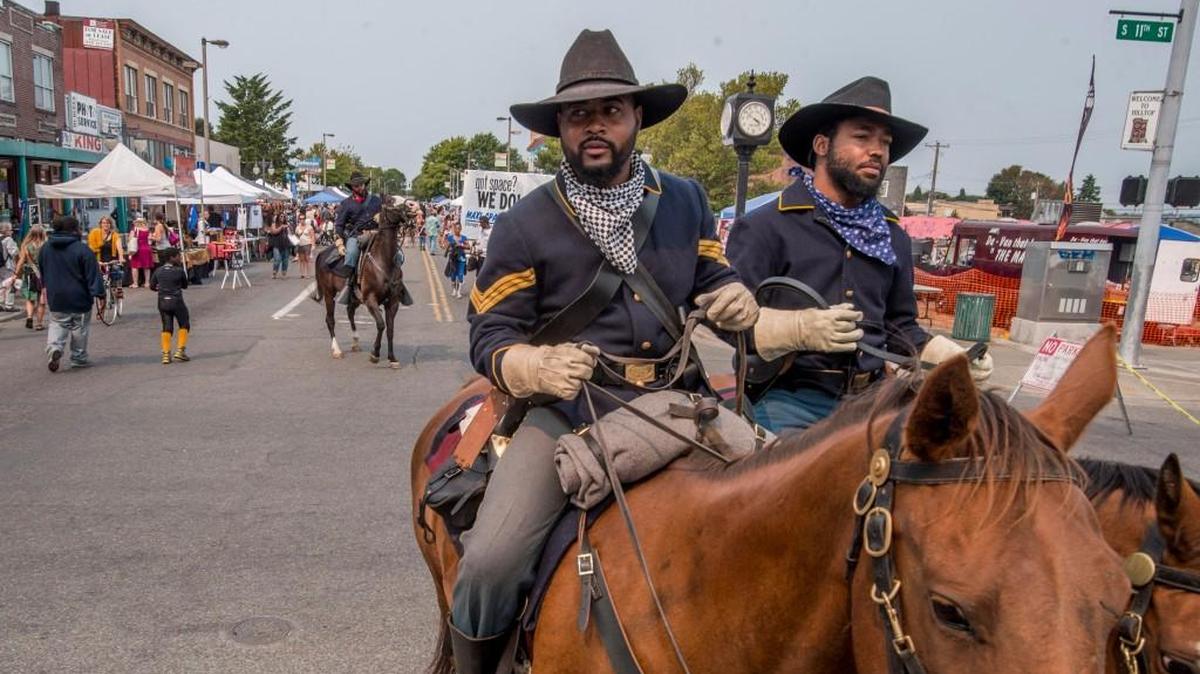 Ninth and 10th Cavalry Buffalo Soldiers of Seattle Re-enactment Organization ride their horses at the Hilltop Street Fair in 2015. The event included performances, booths, car and art exhibitions, food, and kid-friendly fun.