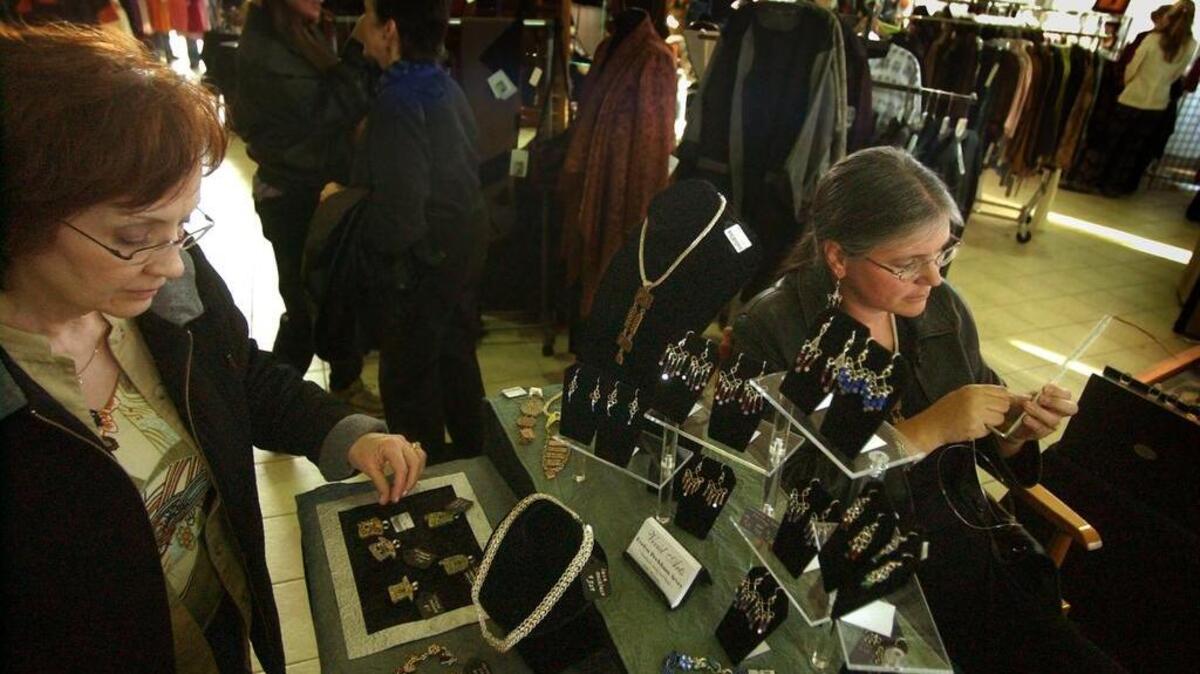 JoAnn Glass(left) of Tacoma looks over the handmade jewelry of Evelyn Arvey (right) at the 2006 RAGS Wearable Art Sale