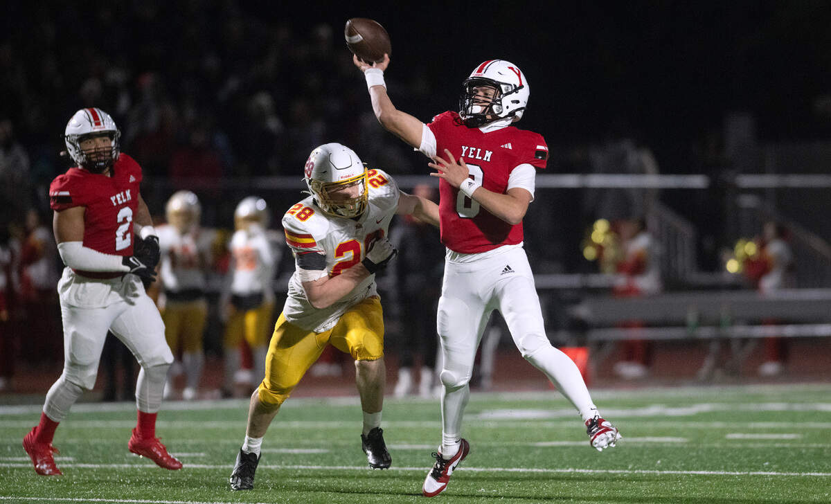 Yelm quarterback Damian Aalona delivers a touchdown pass under pressure from Mount Tahoma linebacker Jeremiah Anderson during Friday night’s 3A state quarterfinal football game at Yelm High School in Yelm, Washington, on Nov. 17, 2023. Yelm won the game, 29-12.