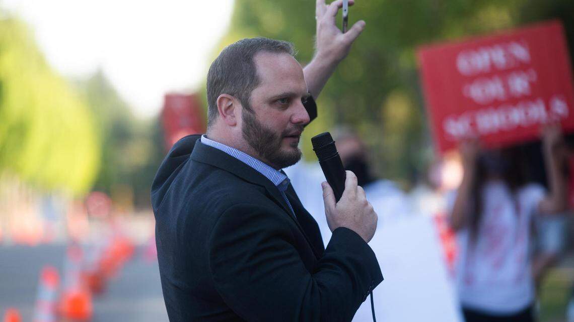 Rep. Jesse Young addresses the crowd during the protest. Nearly 100 kids and adults took part in a “Reopen our Schools” rally near the YMCA in Gig Harbor, Wash., on Thursday, Aug. 13, 2020.
