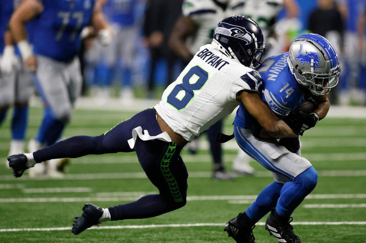 Detroit Lions wide receiver Amon-Ra St. Brown (14) is tackled by Seattle Seahawks cornerback Coby Bryant (8) during the second half of an NFL football game, Sunday, Sept. 17, 2023, in Detroit. (AP Photo/Duane Burleson)