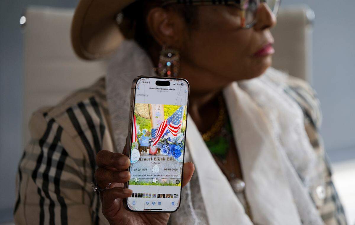 Marcia Carterpatterson holds up a photo of her son Manny Ellis’s tombstone during a press conference following the city of Tacoma settling for $6 million for the in-custody death of her son. Photographed on Wednesday, July 2, 2025, in Des Moines, Washington.