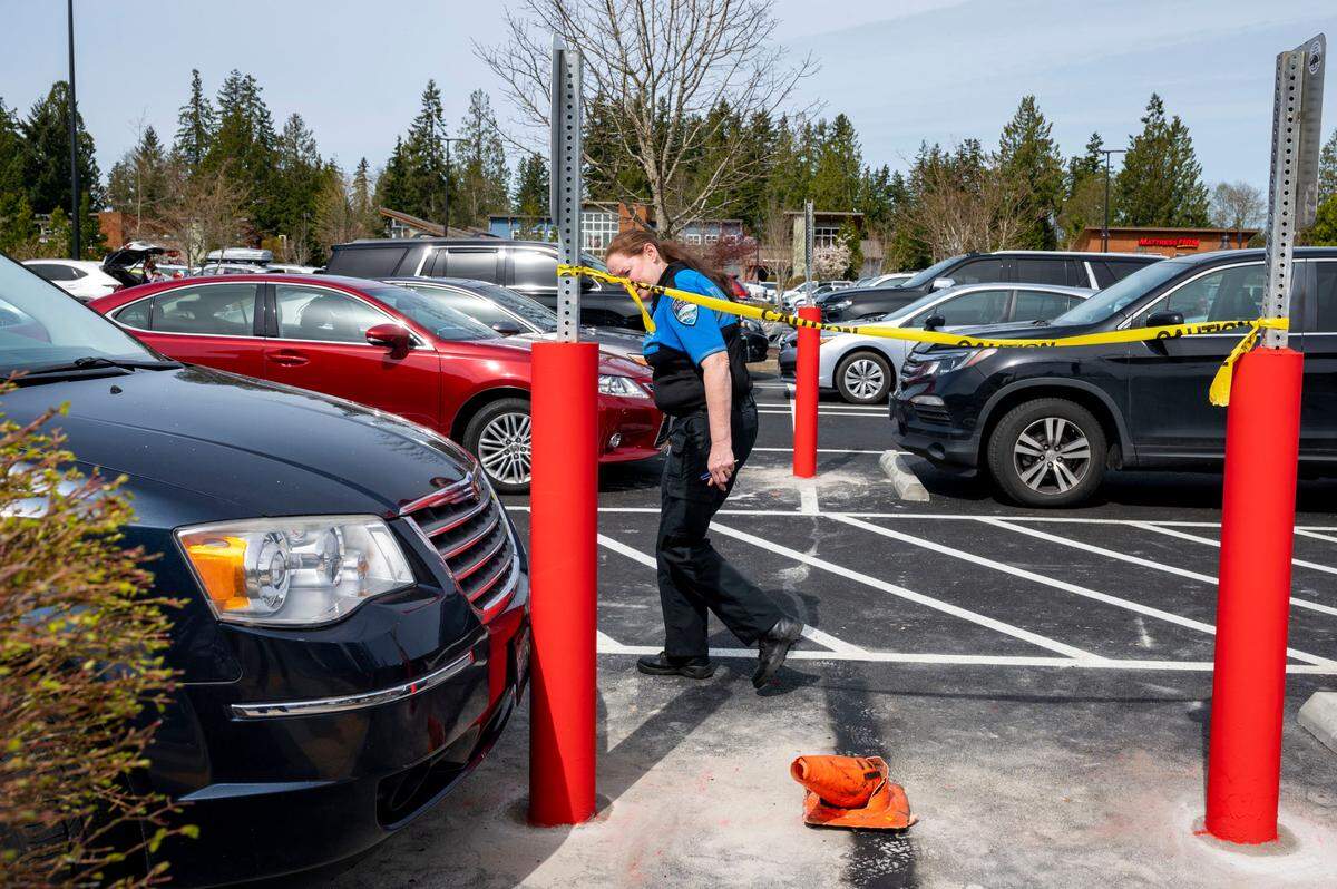 Gig Harbor Police Department volunteer, Kim Crowder, inspects a vehicle she has suspicion to believe has parked in a handicapped spot illegally on Wednesday, April 6, 2022, in Gig Harbor, Wash. 