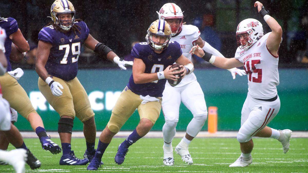 Huskies quarterback Dylan Morris scrambles against the Arkansas State defense during Saturday’s NCAA football game at Husky Stadium in Seattle, Washington, on Sept. 18, 2021.