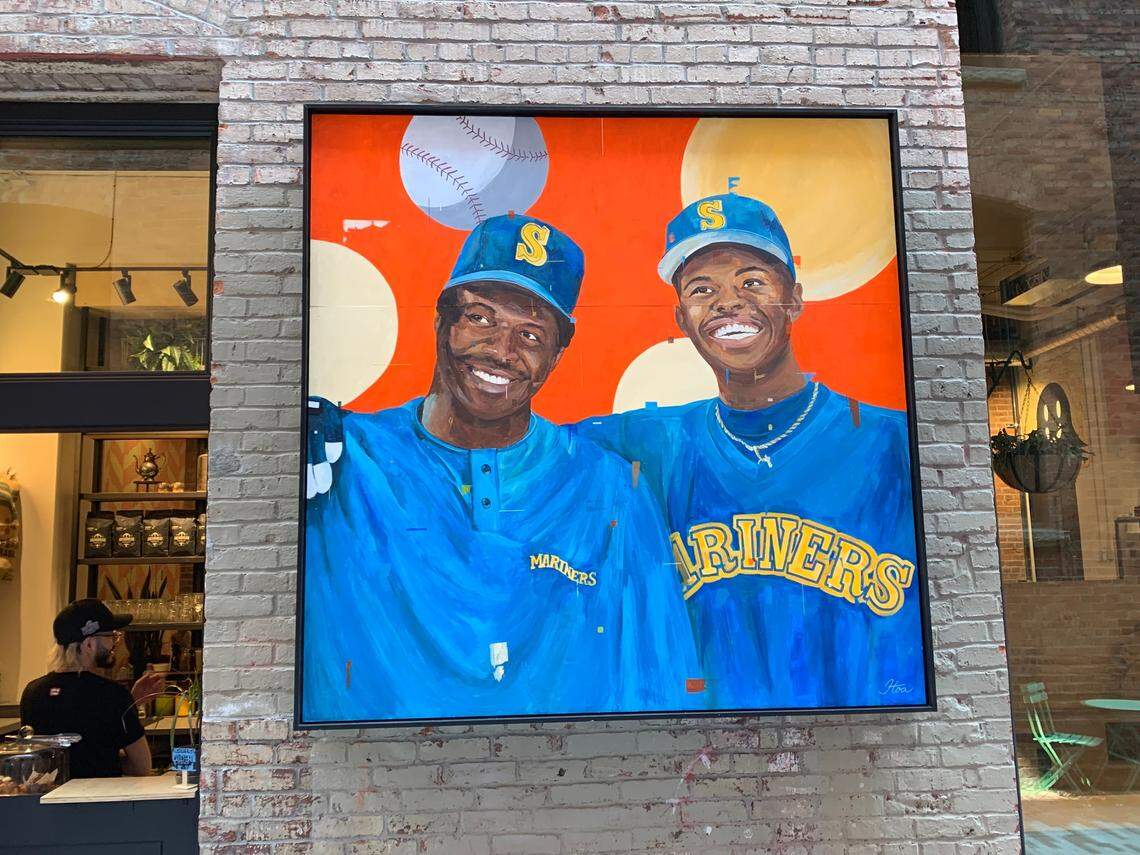 A painting displayed in an alley outside Pioneer Square art galleries in Seattle July 5, 2023, depicts Mariners icon Ken Griffey Jr. (right) debuting in the major leagues with his dad for Seattle in 1990. On Aug. 31 of that year the 40-year-old Griffey Sr. and his 20-year-old son became the first father and son to play as teammates in an MLB game. Two weeks later they became the first father-son duo to hit back-to-back home runs in an MLB game. The art was part of an exhibit for the 93rd MLB All-Star Game in Seattle July 11, 2023.