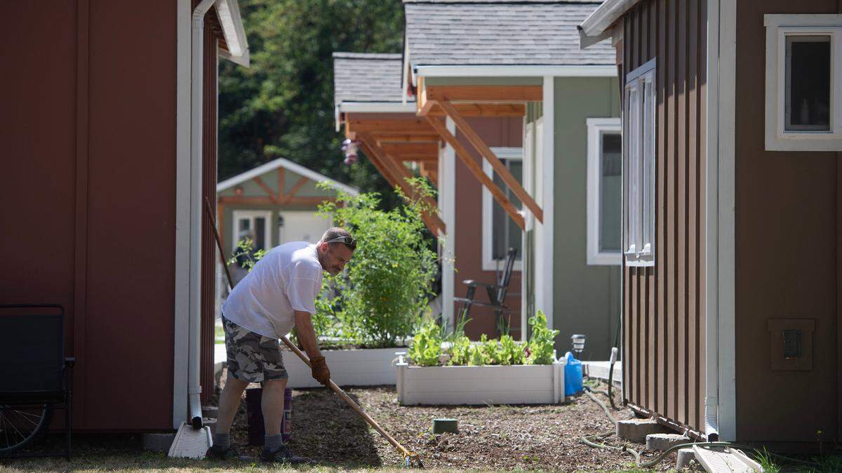 Thomas Riner clears weeds around his raised garden beds outside his home at the Quixote Orting Veterans Village. The soil in raised beds drains quicker and warms sooner than soil at ground level, so vegetables can go into the ground sooner if your beds are raised. 