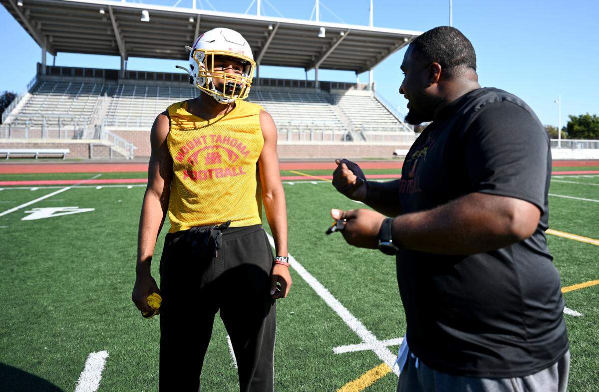 Mount Tahoma’s Jah Hah Abdullah talks to head coach Keith Terry during practice at Mount Tahoma High School, Friday, Aug. 18, 2023, in Tacoma, Wash.