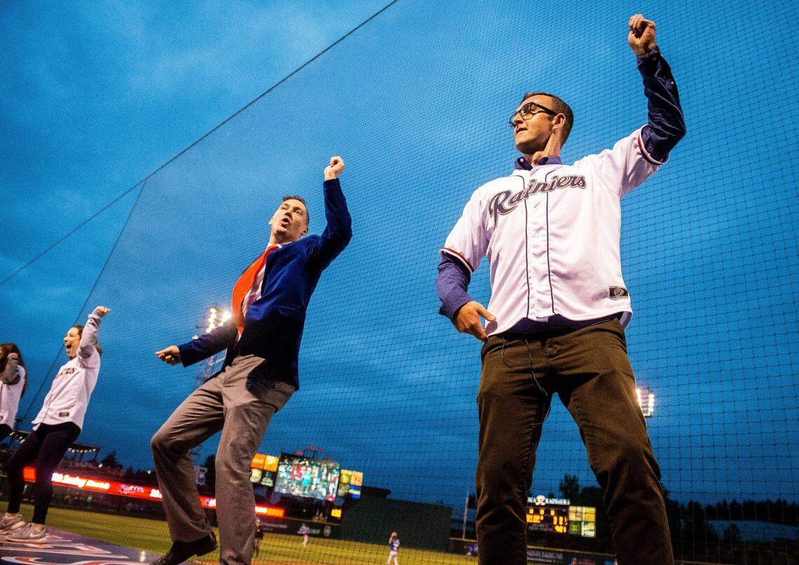 Columnist Matt Driscoll dances on the third base dugout with Casey Catherwood, creative director with the Tacoma Rainiers, and the Rainier Fun Squad, during the seventh inning stretch of the Tacoma Rainiers’ game against the Las Vegas 51s at Cheney Stadium on June 28, 2018.