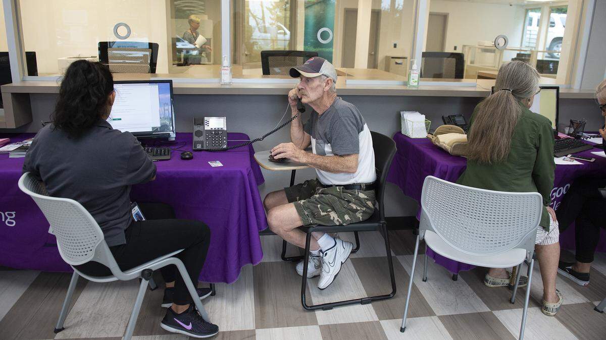 In a photo taken last August, James Johnson (center) of Port Orchard got help at the Good to Go customer service center in Gig Harbor.
