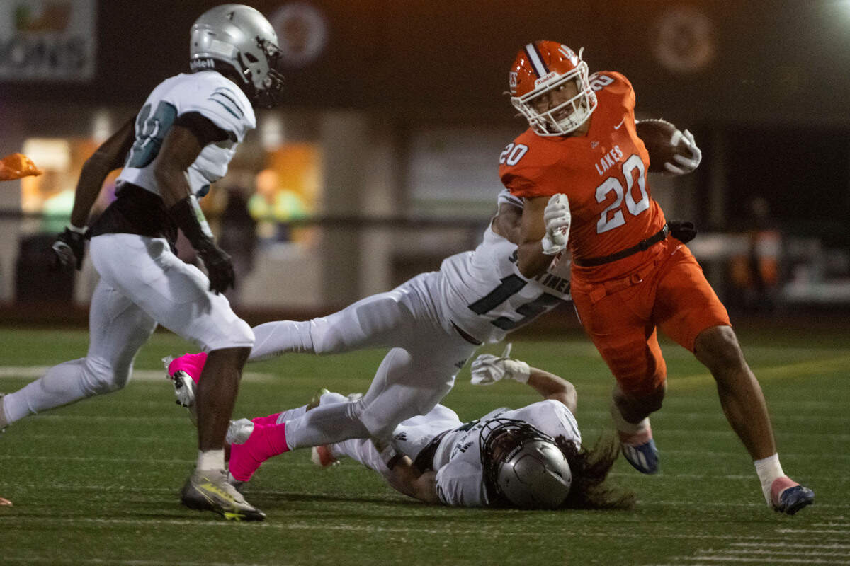Lakes running back Leo Pulalasi turns the corner as he is tackled by Spanaway Lake Nakobe Romeo during the first quarter of a 3A PCL game on Monday, Oct. 17, 2022, at Harry E. Lang Stadium in Lakewood, Wash.