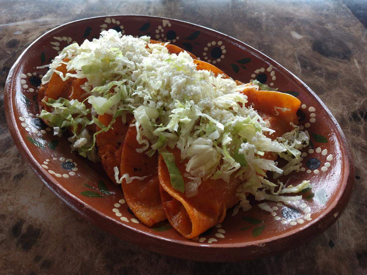 Tacos al vapor, filled with shredded chicken and dipped in a red sauce, from Mi Casa Mexican Restaurant in Lakewood.