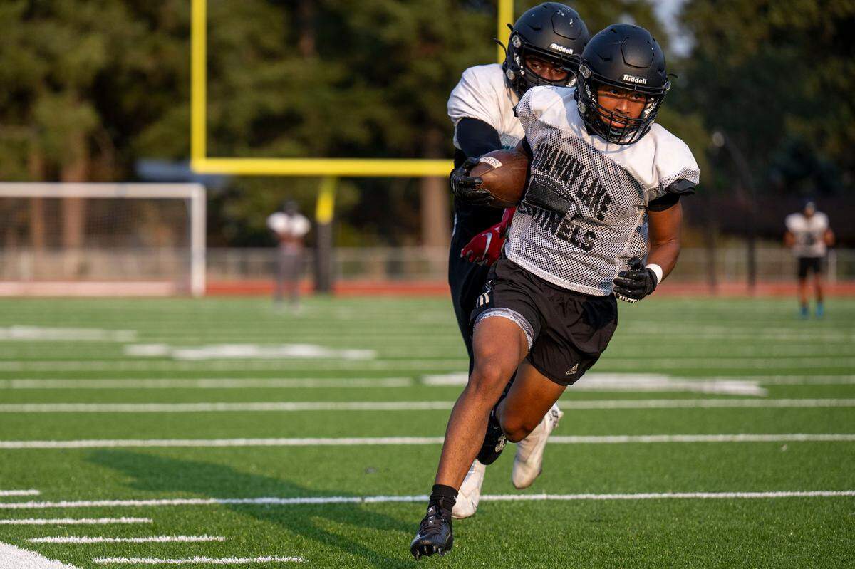 After catching a pass, Spanaway Lake receiver LaRon Paige runs up field during team drills at practice on Wednesday, Aug. 23, 2023, at Spanaway Lake High School in Spanaway, Wash.
