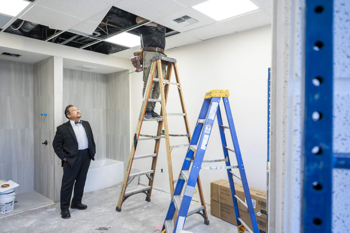 Chan Hwang, left, a physical medicine and rehabilitation doctor, looks up at the work being done on a birthing room at the Blessed Hope Health Center during a tour of the space under construction on Friday, July 25, 2025, in Tacoma. The two-story building expects to offer dental, vision, and birth and child care services, as well physical therapy and a pharmacy.