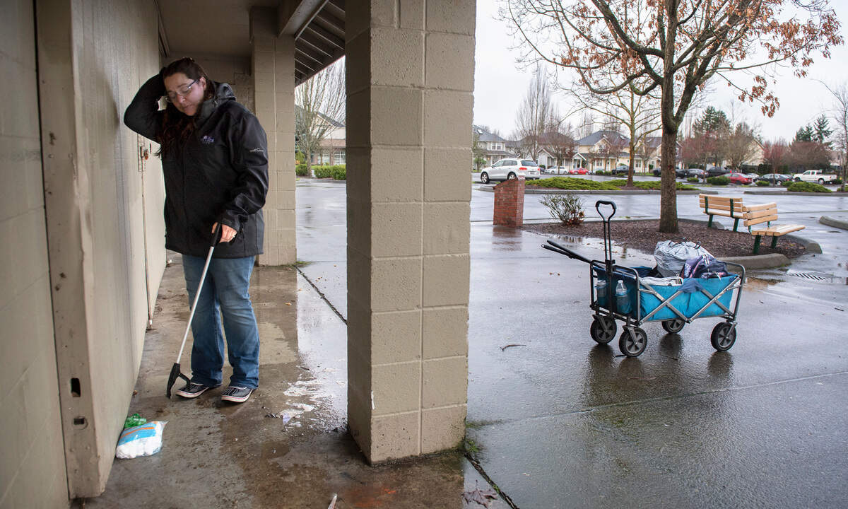 Katlin Lawless, founder of the unofficial “Sumner Cleaning Crew” that now boasts more than 100 members, picks up trash on her walk around Daffodil Valley Athletic Complex in Sumner, Washington, on Saturday, Dec. 11, 2021.