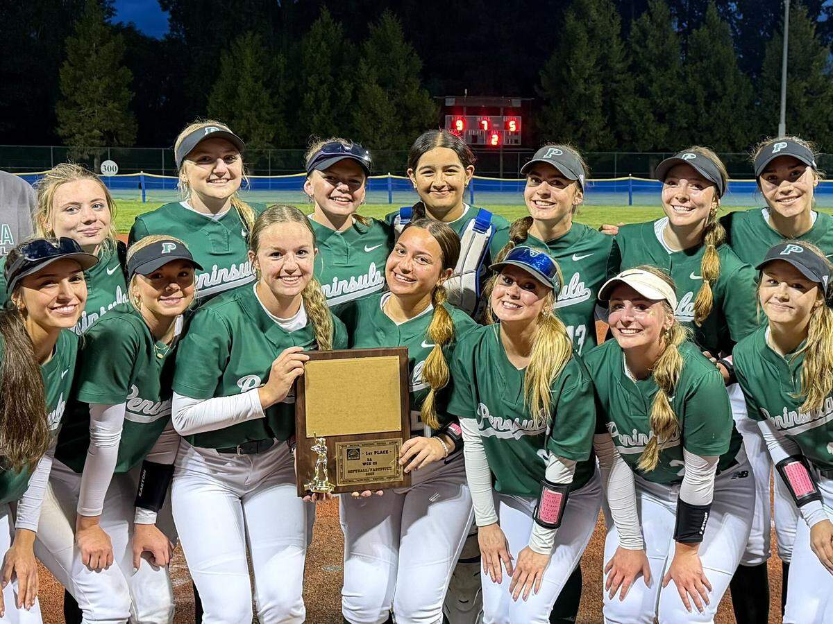 Peninsula High School’s softball team poses for a portrait with the first-place trophy after defeating Timberline, 9-5, in the Class 3A District 3 championship game on May 16, 2026, at Regional Athletic Complex in Lacey, Wash.