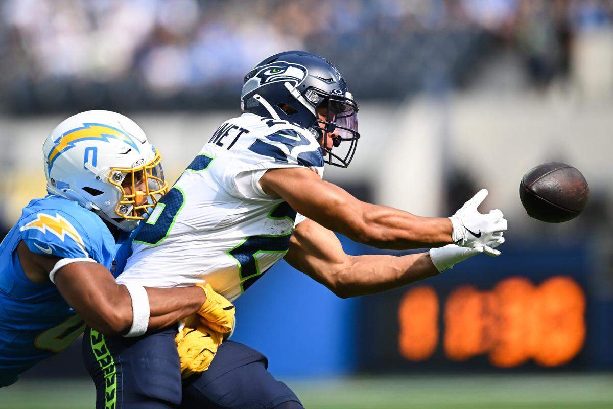Aug 10, 2024; Inglewood, California, USA; Seattle Seahawks running back Zach Charbonnet (26) attempts to catch the ball against Los Angeles Chargers linebacker Daiyan Henley (0) during the first quarter at SoFi Stadium. Mandatory Credit: Jonathan Hui-USA TODAY Sports