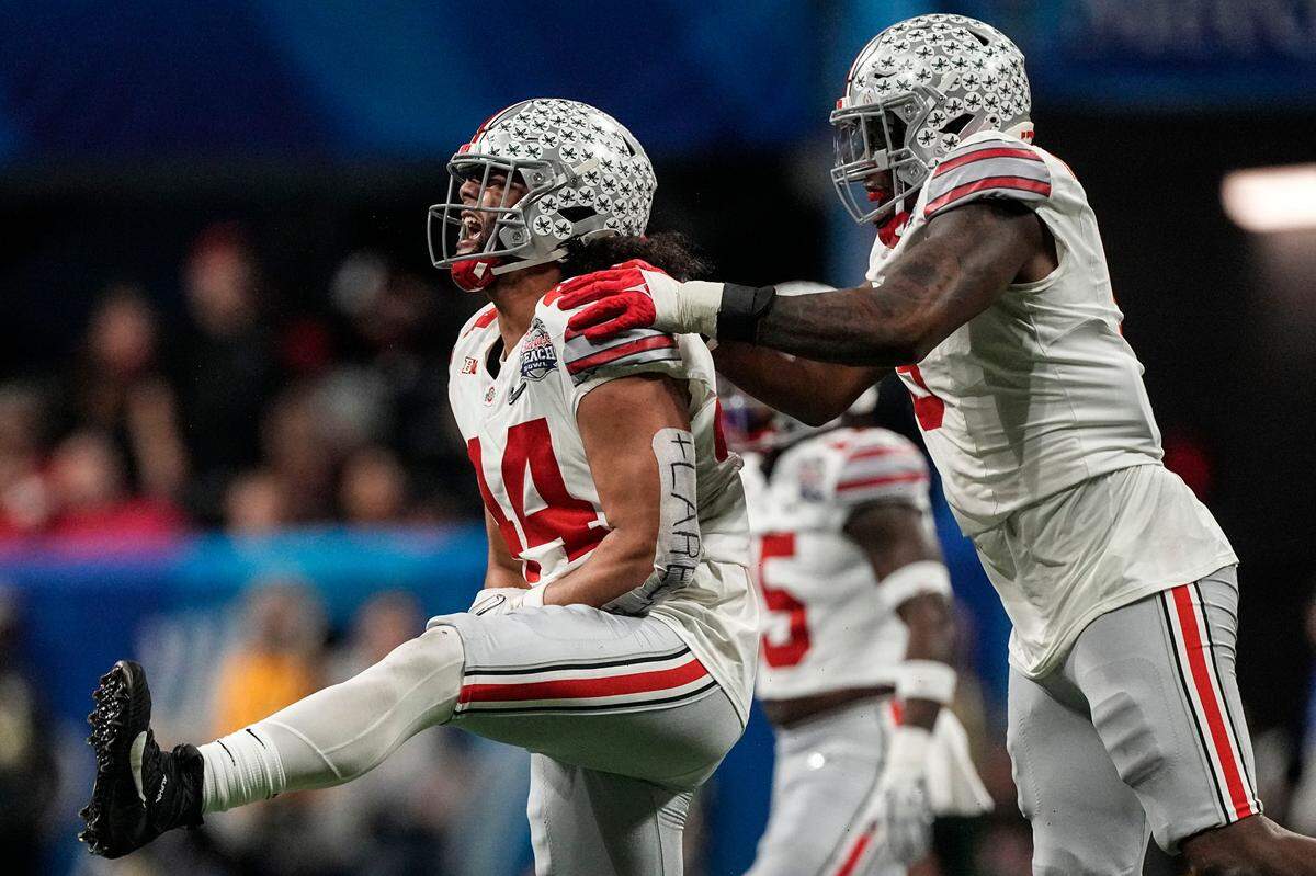 Ohio State defensive end J.T. Tuimoloau (44) and Ohio State defensive end Zach Harrison (9) celebrate stopping Georgia during the second half of the Peach Bowl NCAA college football semifinal playoff game, Saturday, Dec. 31, 2022, in Atlanta. (AP Photo/John Bazemore)