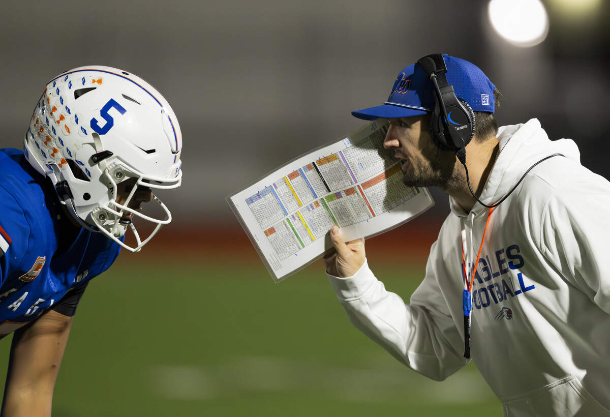 Graham Kapowsin head coach Jeff Logan talks with Graham Kapowsin quarterback Aloalii Faafolau (5) during the second half of the opening round 4A state tournament game against Kennedy Catholic Lancers at Art Crate Field, on Saturday, Nov. 15, 2025, in Spanaway, Wash.