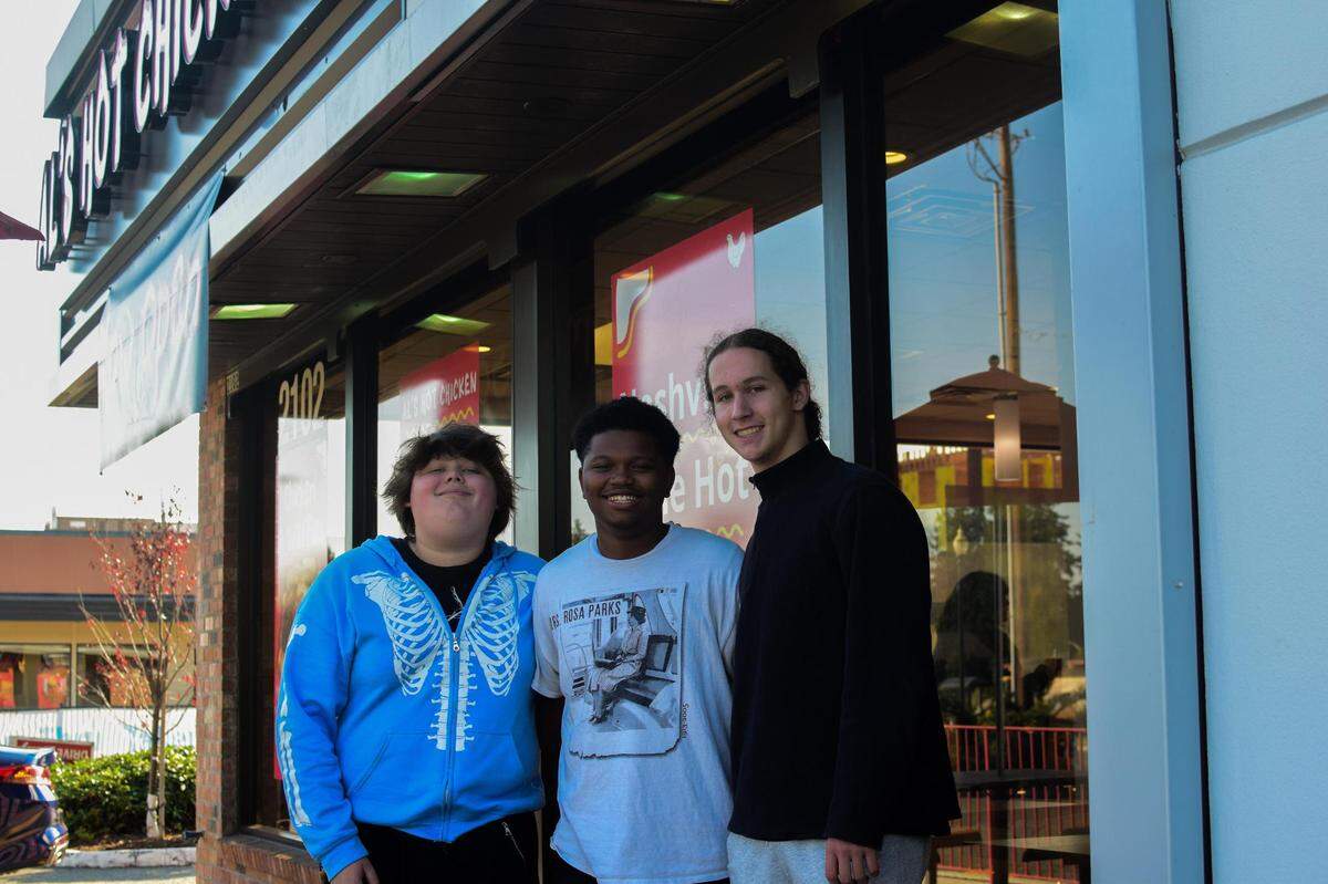 Al’s Hot Chicken promoted a giveaway of weekly free meals to the first 100 customers at its Oct. 1 grand opening. From left, Mikui Shedore, Daylin Jones and Landon Koltes arrived the afternoon prior to stake out their spot. They were among the first five people to receive their “free chicken passes” after spending the night outside the restaurant.