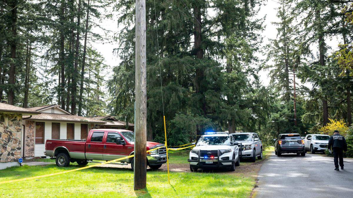Law enforcement personnel from the Pierce County Sheriff’s Department wait to begin investigating the scene of a homicide in Frederickson on Tuesday, April 12, 2022. On Monday, deputies said online reporting of some crimes will allow deputies to respond more quickly to in-progress and violent crimes.