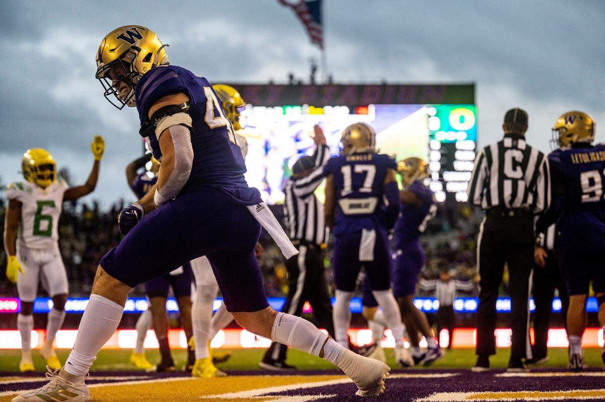 Washington linebacker Carson Bruener (42) celebrates after helping tackle Oregon running back Travis Dye (26) in the endzone for a safety during the first quarter of a Pac-12 game on Saturday at Husky Stadium in Seattle.