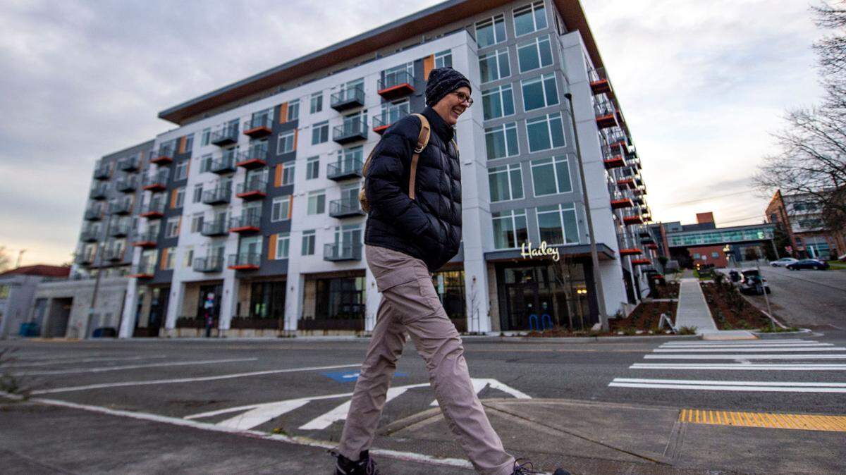 A person walks down Tacoma Avenue past The Hailey Apartments in 2022, in Tacoma. The city’s MFTE program, which projects such as The Hailey use in development, is undergoing review.