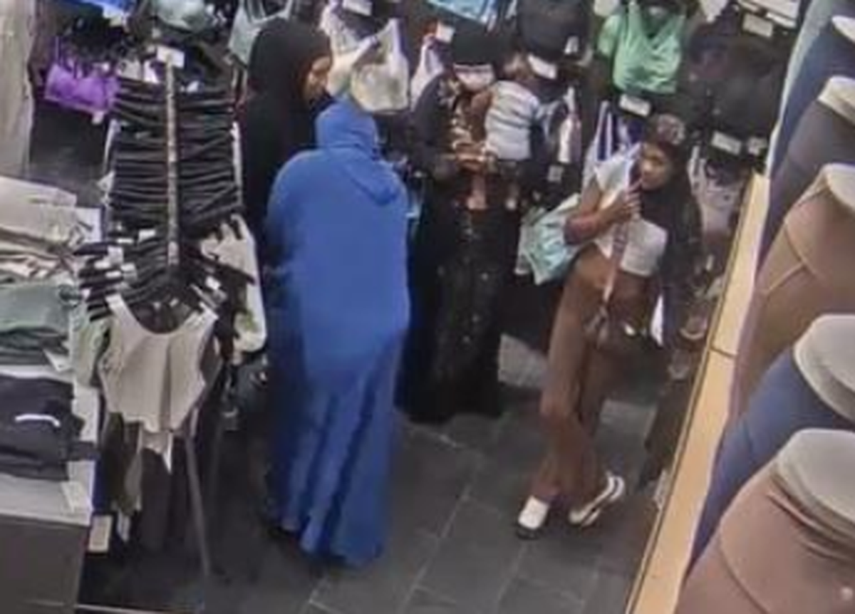 Janeice Downs, in blue, is shown on surveillance footage allegedly hiding several pairs of Lululemon pants under Janeice Wiley’s outfit, which detectives described as a burqa. Their suspected accomplices in the Aug. 15, 2023 theft of a Bellevue store, Memory Yearby and Reality Leavens, stand nearby.