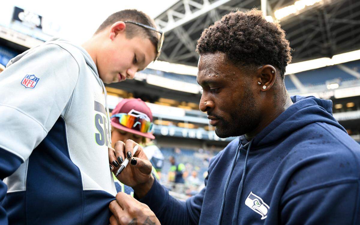 Seattle Seahawks wide receiver DK Metcalf (14) signs autographs before of the preseason game against the Minnesota Vikings at Lumen Field, Thursday, Aug. 10, 2023, in Seattle, Wash.