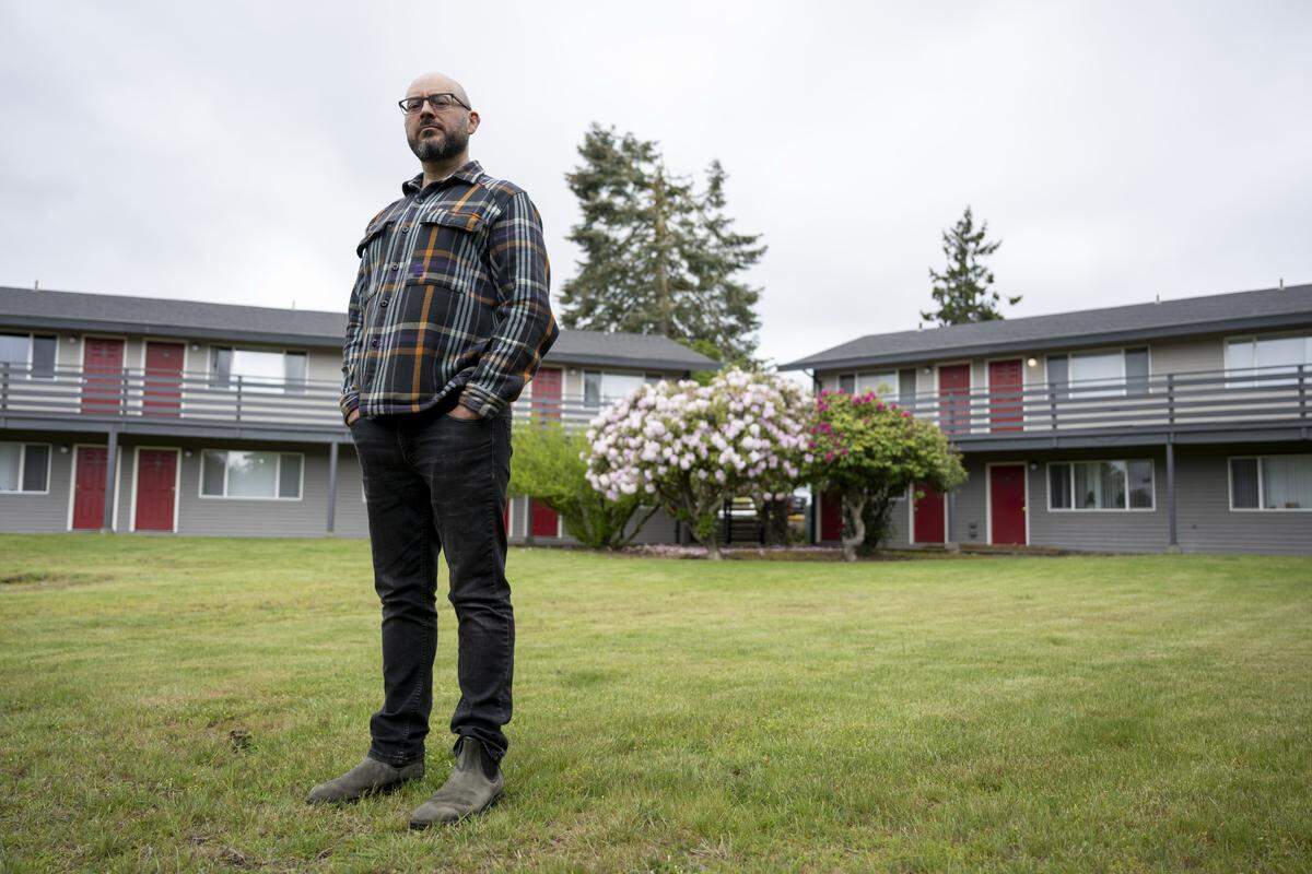 Ty Moore, co-executive director for Tacoma for All, stands outside of apartments at Westside Estates on Wednesday, May 13, 2026, in Tacoma, Wash.