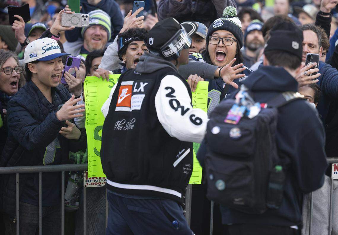 Seahawks wide receiver Tory Horton walks along the Super Bowl parade route as fans react on Wednesday, Feb. 11, 2026, in downtown Seattle.