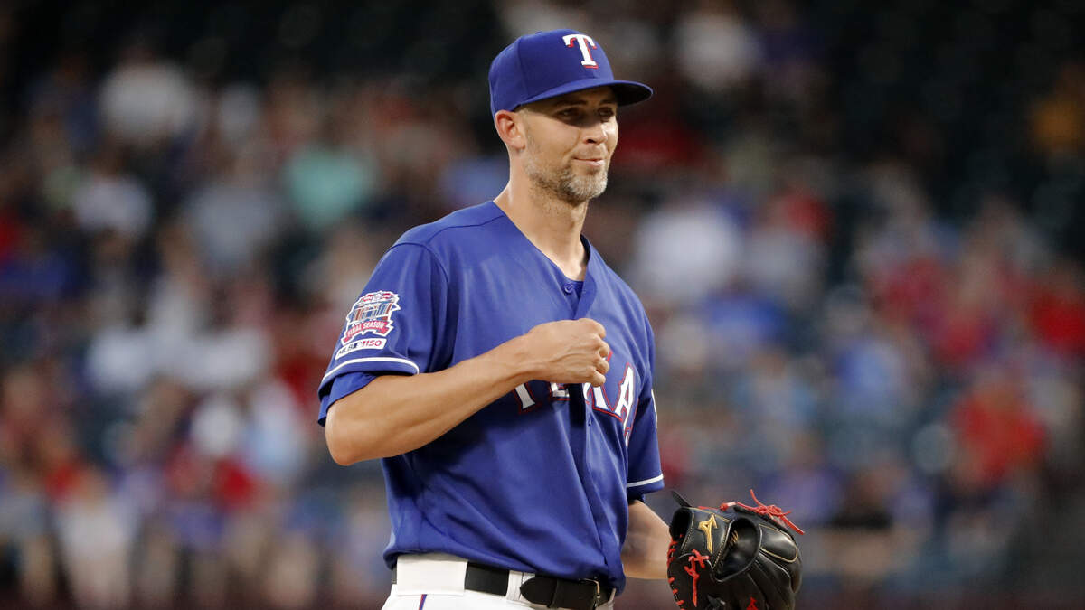 Texas Rangers starting pitcher Mike Minor smiles as he stands on the mound while working against the Seattle Mariners during the fourth inning of a baseball game in Arlington, Texas, Wednesday, July 31, 2019.