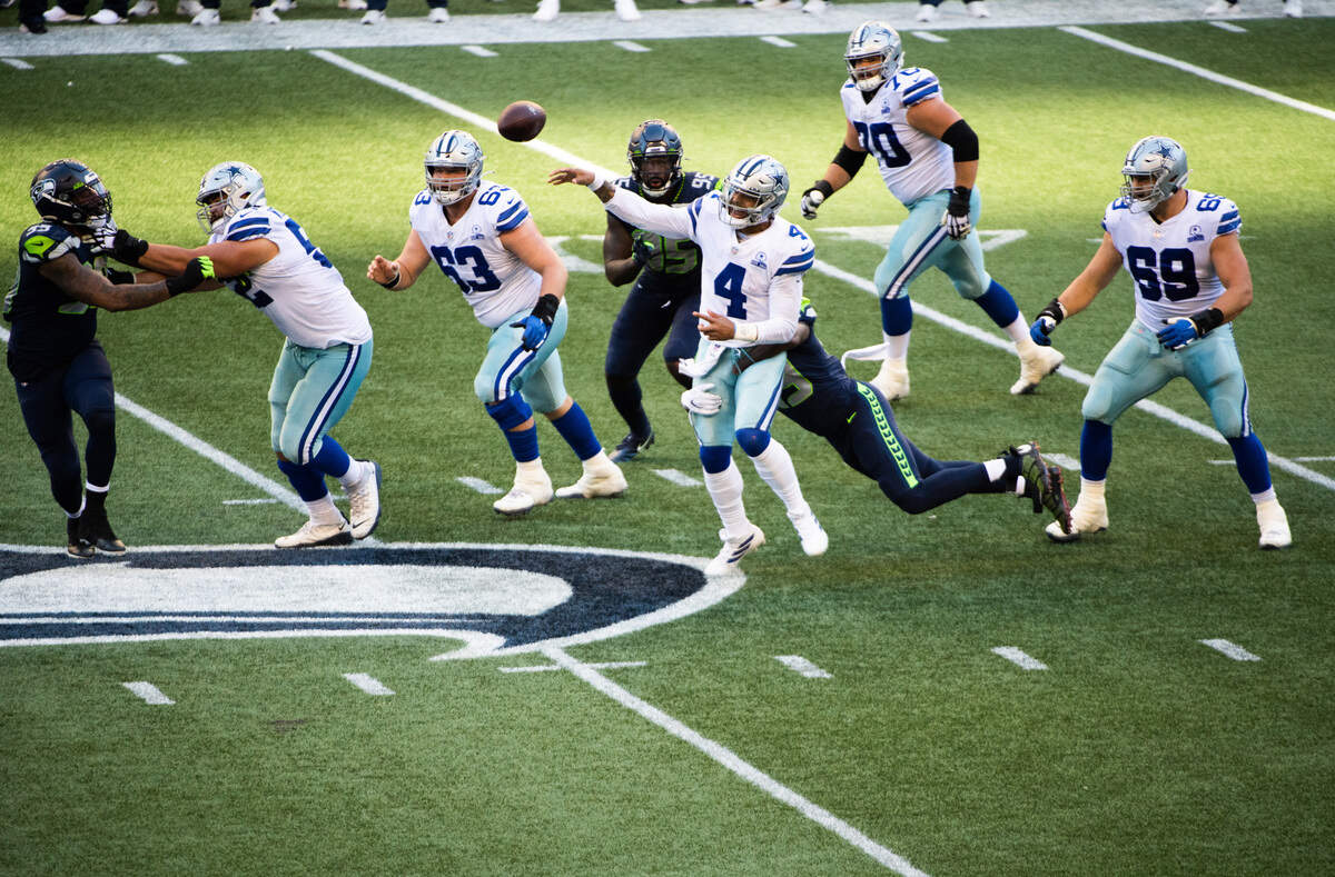Dallas Cowboys’ Day Prescott throws while hit by Seattle’s Shaquem Griffin during the fourth quarter. The Seattle Seahawks played the Dallas Cowboys in a NFL football game at CenturyLink Field in Seattle, Wash., on Sunday, Sept. 27, 2020.