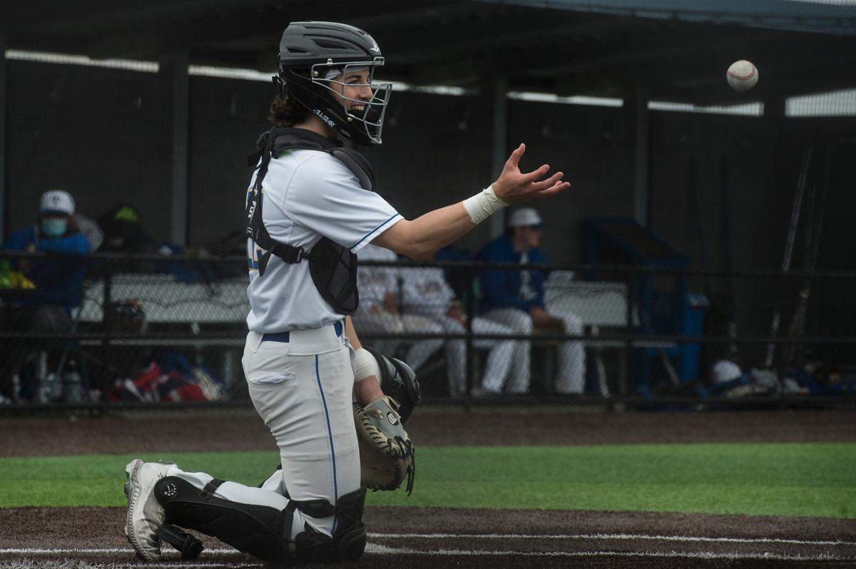 Tahoma High School catcher Carson Ohland smiles as he catches a ball during the Class 4A/3A North Puget Sound League baseball championship game on Saturday, May 22, 2021 in Maple Valley, Wash. Tahoma topped Kentlake, 5-1.
