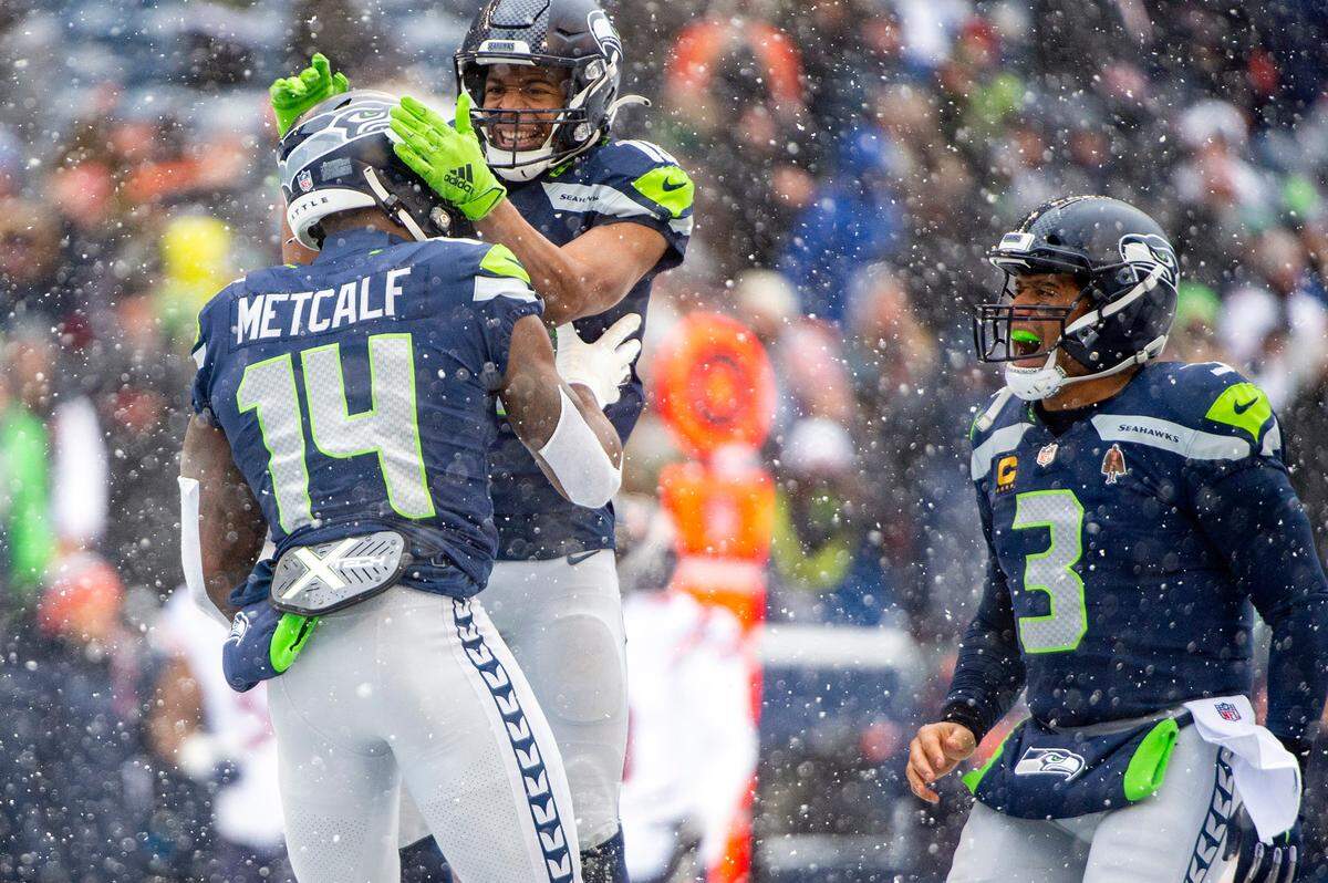 Seattle Seahawks wide receiver Tyler Lockett (16) and quarterback Russell Wilson (3) celebrate after wide receiver DK Metcalf (14) caught a touchdown pass from Wilson during the first quarter of an NFL game on Sunday afternoon at Lumen Field in Seattle.