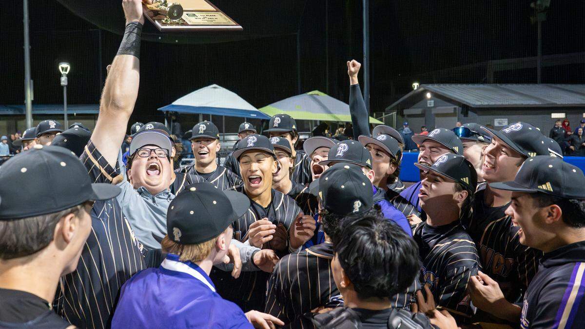 Puyallup celebrates their 4A District Championship win over Sumner, hoisting the trophy in the air, on Saturday, May 17, 2025, at Tahoma High School in Maple Valley, Wash.