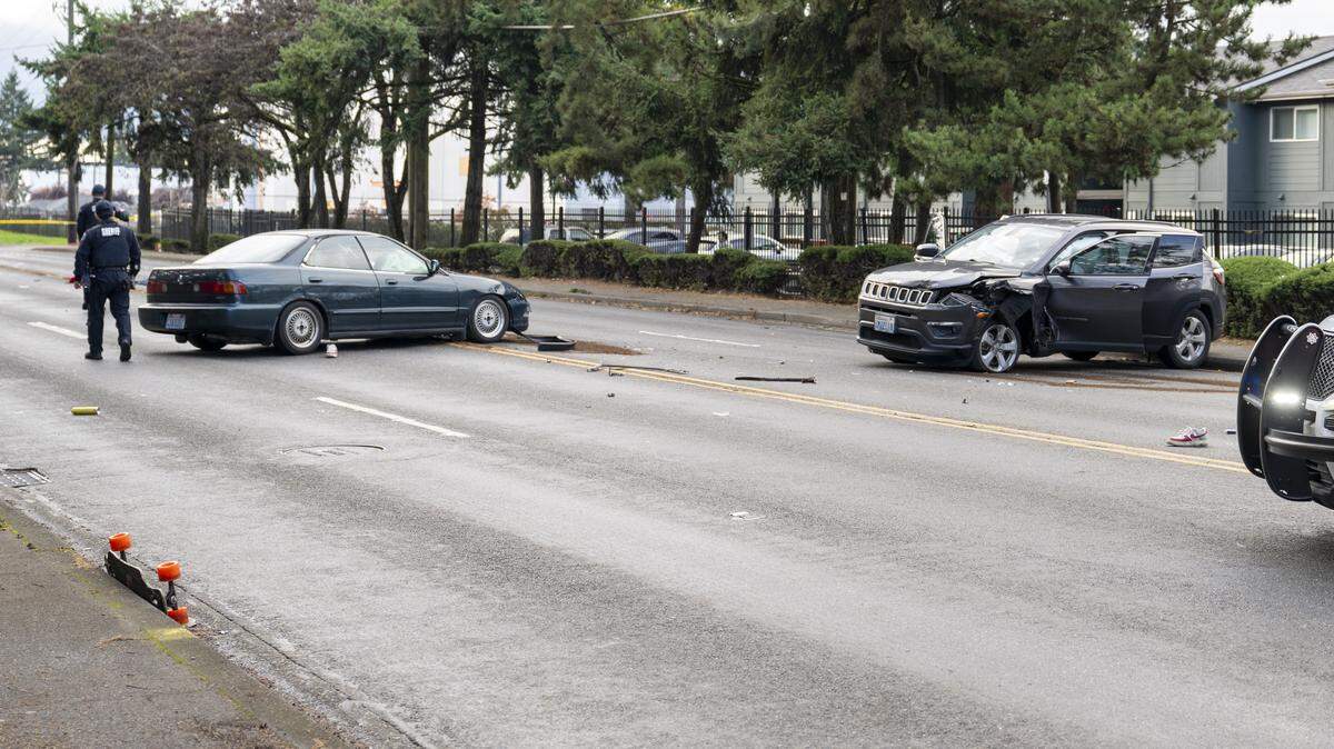 Police move about the scene where a driver struck a pedestrian and another vehicle on 96th Street South on Monday, Nov. 10, 2025, in Tacoma, Wash. Initial reporting of the crash on Monday reported two people, one on a bicycle and another on a skateboard, were struck.