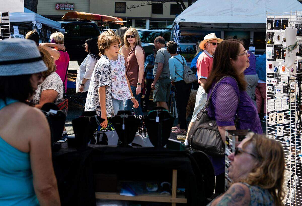 People walk along a row of arts vendors during the Gig Harbor Summer Arts Festival in 2019.
