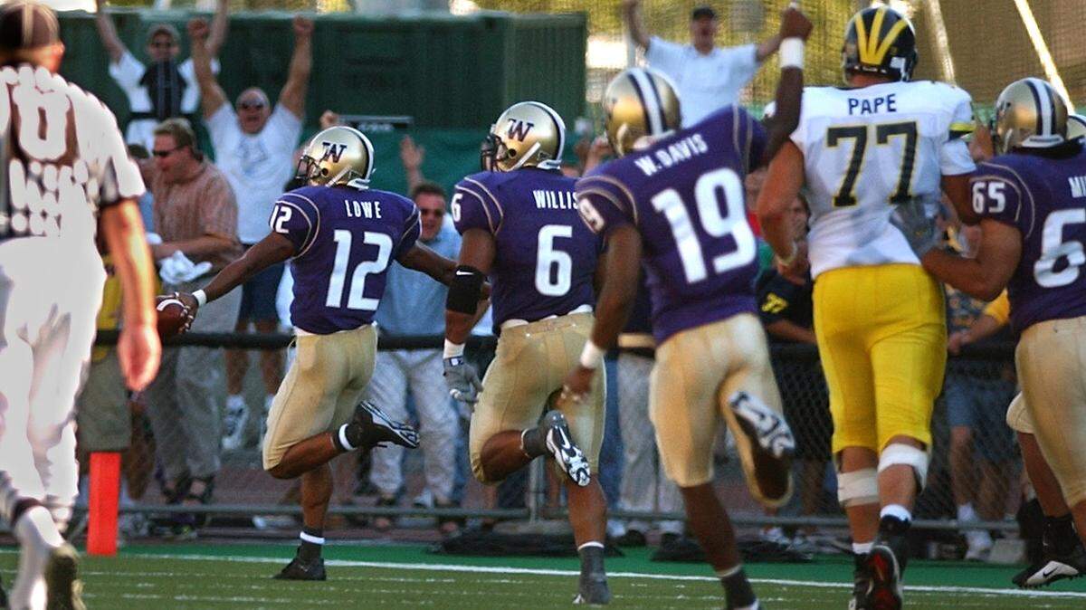 Husky cornerback Omare Lowe (12) prances into the end zone with a touchdown interception in the fourth quarter. The University of Washington defeated the University of Michigan at Husky Stadium in Seattle, Wash. on Saturday, Sept. 8, 2001.
