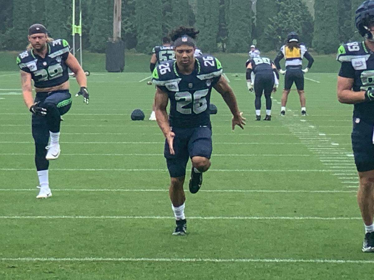 Tight end Brady Russell (38) and running back Zach Charbonnet (26) warm-up for the start of the fifth practice of Seattle Seahawks NFL training camp at the Virginia Mason Athletic Center in Renton Monday, July 29, 2024.