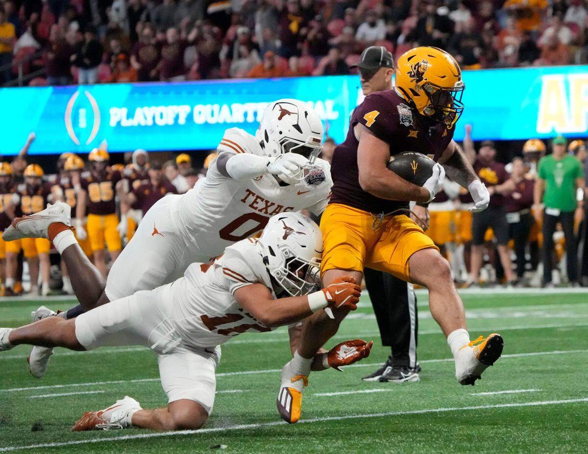 Arizona State running back Cam Skattebo (4) runs past Texas linebacker Anthony Hill Jr. (0) and Texas linebacker Liona Lefau (18) during the third quarter of the Chick-fil-A Peach Bowl in Atlanta on Wednesday, Jan. 1, 2025.
