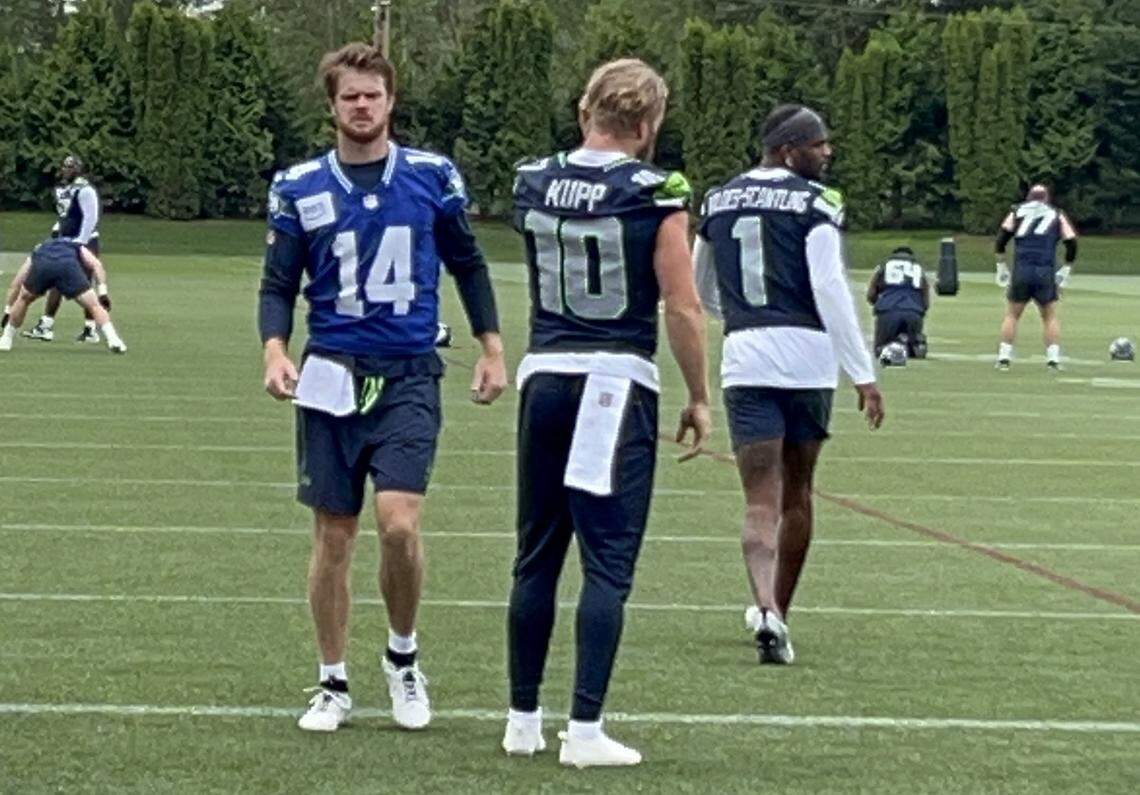 New Seahawks quarterback Sam Darnold (14) jogs past Seattle’s new wide receivers Cooper Kupp (10) and Marques Valdes-Scantling (1) warming up for the fifth practice of organized team activities (OTAs) at the Virginia Mason Athletic Center in Renton June 4, 2025.