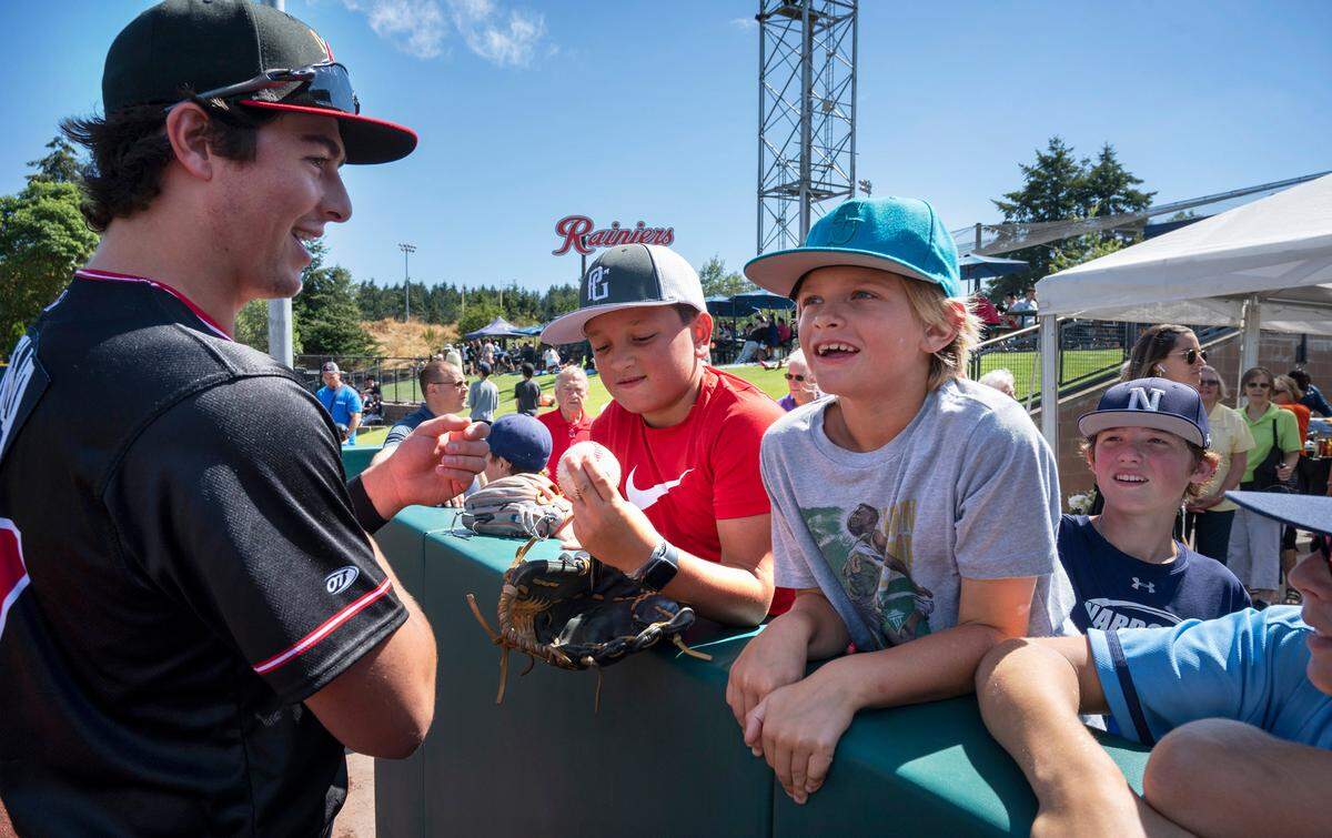 Former Gig Harbor standout Michael Toglia - now a first baseman/outfielder with the AAA Albuquerque Isotopes - talks with Hunter Ramos (center), AJ Perkins and other members of the Gig Harbor Narrows select baseball team as he returns to the Pacific Northwest for a six-game series against the Tacoma Rainiers at Cheney Stadium in Tacoma, Washington on Tuesday, Aug. 16, 2022. Toglia played for the Narrows team when he was a little leaguer.