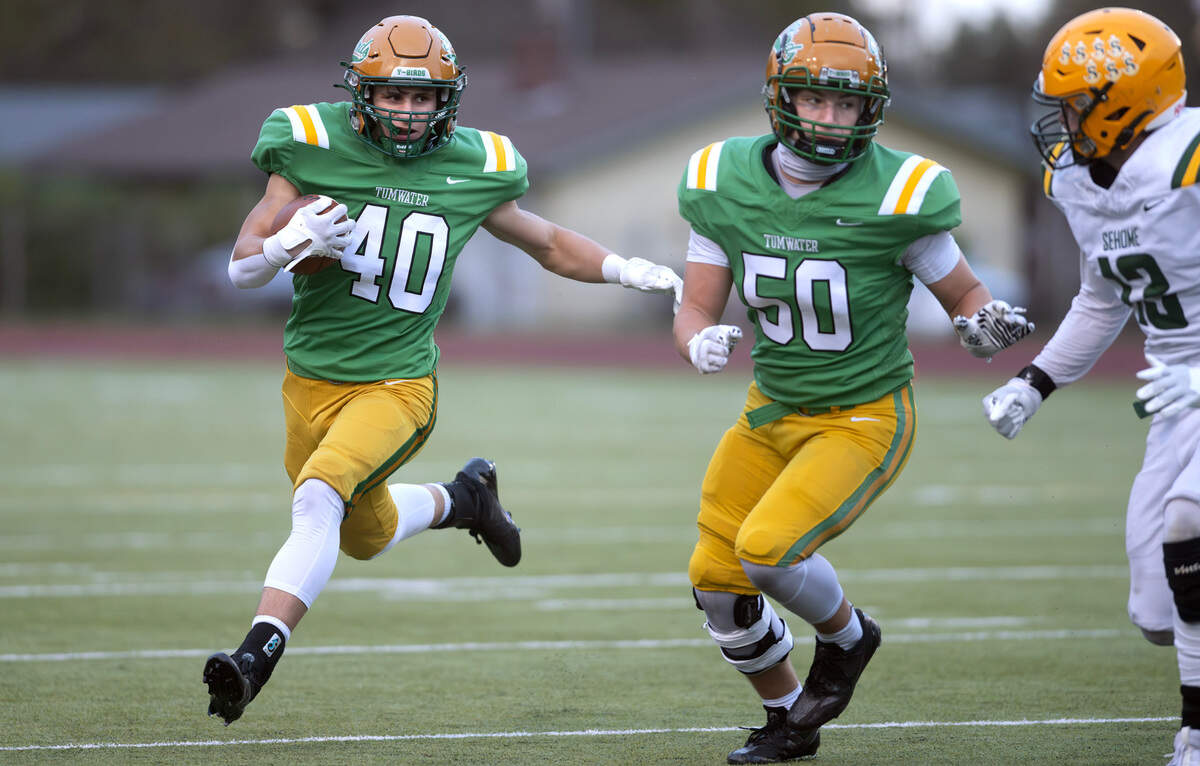 Tumwater running back Kyson Sayamnet follows Blake Heryford’s block against Sehome defensive back Nicholas Smith during Satuday afternoon’s state playoff game at Tumwater District Stadium in Tumwater, Washington, on Friday, Nov. 23, 2024. Tumwater won the game, 70-7, to advance to the state semifinals.