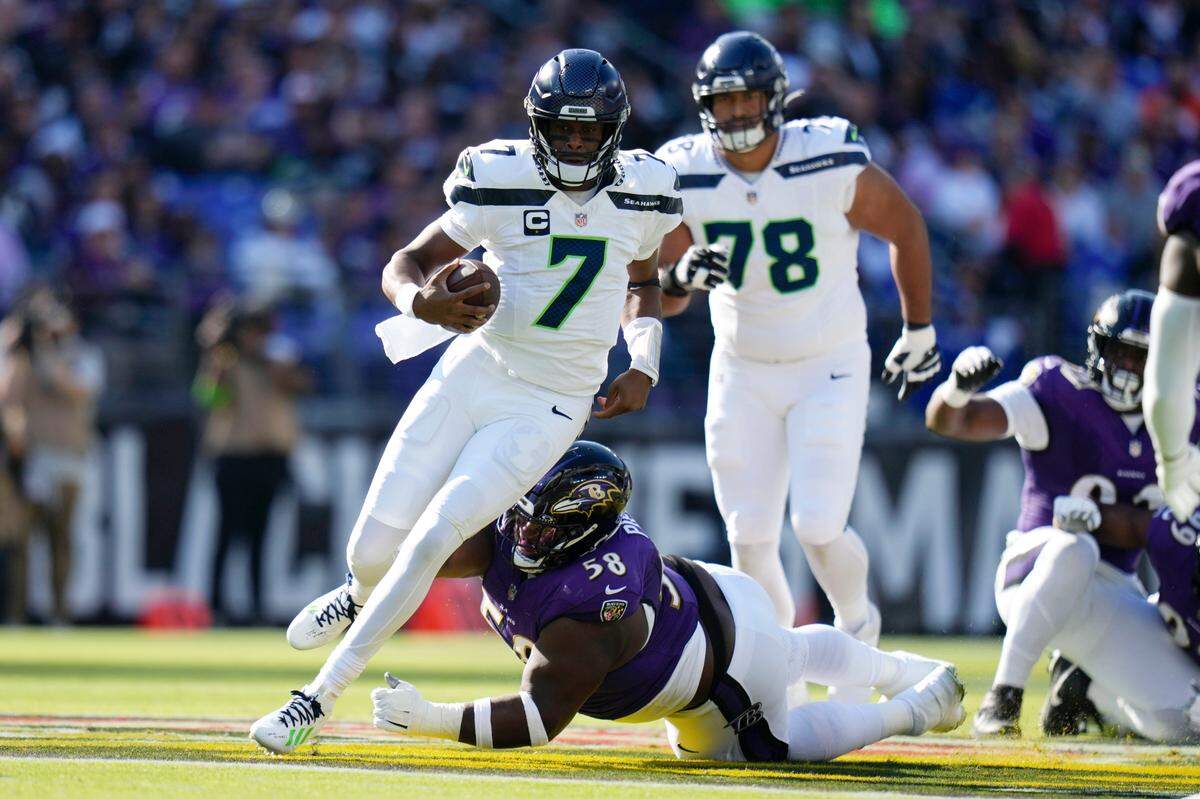 Seattle Seahawks quarterback Geno Smith (7) runs from Baltimore Ravens defensive tackle Michael Pierce (58) during the first half of an NFL football game, Sunday, Nov. 5, 2023, in Baltimore. (AP Photo/Alex Brandon)