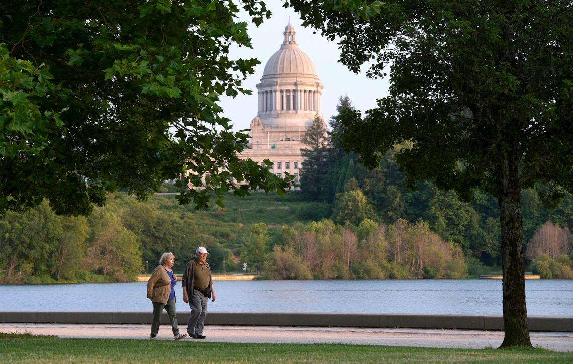 A couple walks along Capitol Lake in Olympia, Washington, on Friday, July 2, 2021.