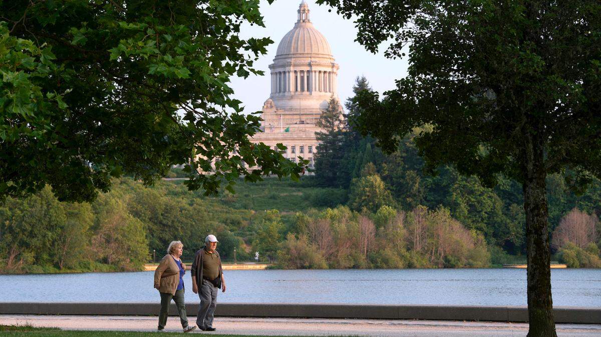 A couple walks along Capitol Lake in Olympia