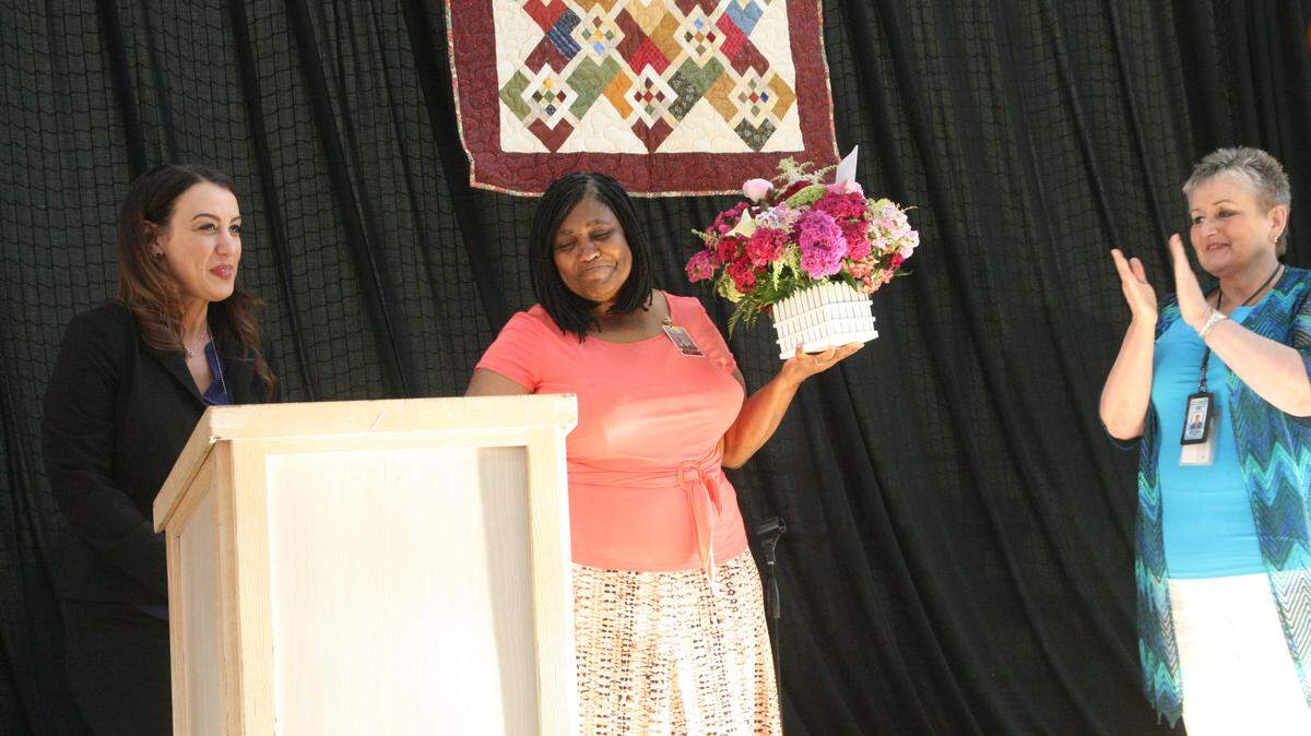 At the annual Washington Correction Center for Women Volunteer Recognition Event last month, from left, Associate Superintendent of Programs Felice Davis, congratulates Volunteer of the Year award winner Deborah Bass of Bible Scope Ministries' Anticipate Prison Fellowship program. Bass is applauded by WCCW Community Partnership Coordinator Chrislee McConnaughey, far right.