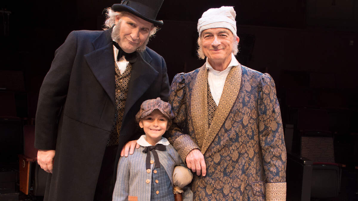 Piper Harden, 7, as Tiny Tim with Ebenezer Scrooges Ian Bell, left, and David Pichette in “A Christmas Carol.”