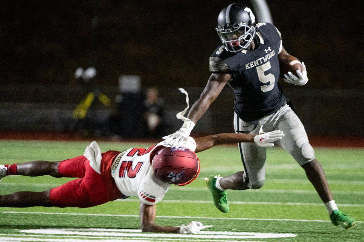 Kentwood running back Antoine Lee stiff arms Kennedy Catholic’s Geron White as he runs up the field during the fourth quarter of a 4A NPSL game on Thursday, Sept. 15, 2022, at French Field in Kent, Wash.
