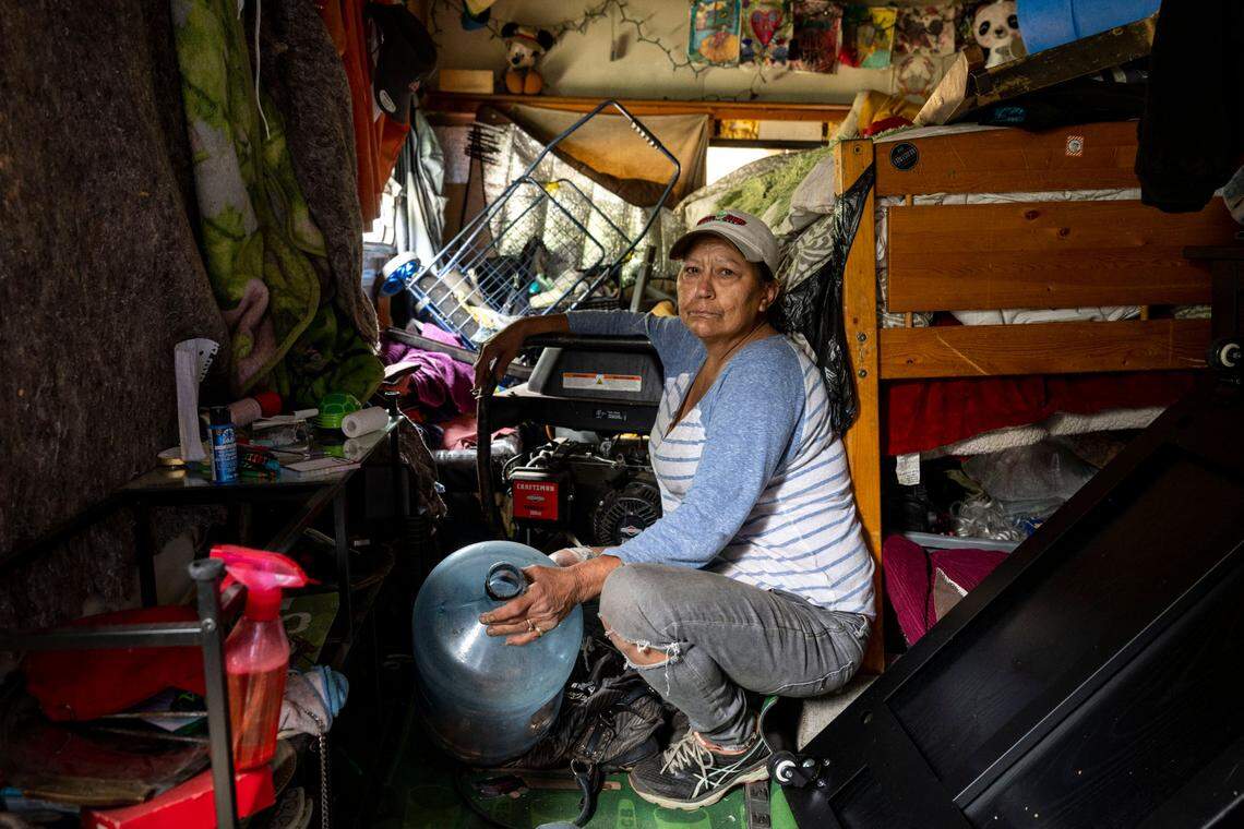 Lisa Zollner poses for a portrait inside her trailer parked on city property along South Tyler Street on Tuesday, May 30, 2023, in Tacoma, Wash. Zollner was going through coins in hopes of collecting enough money to pay someone for gas so she could get her trailer out of an area that was being cleared that morning.